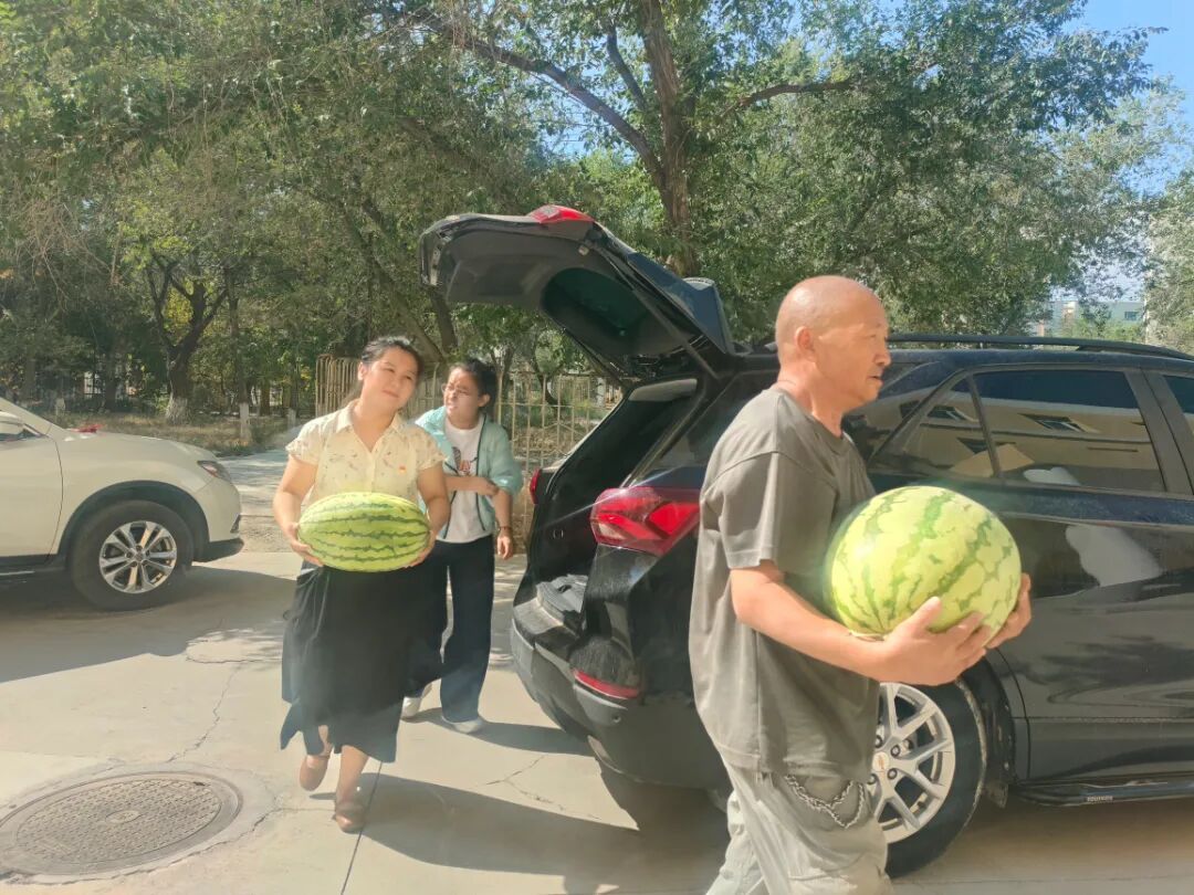 凯旋街道滨河社区社区工作人员在搬运西瓜.jpg